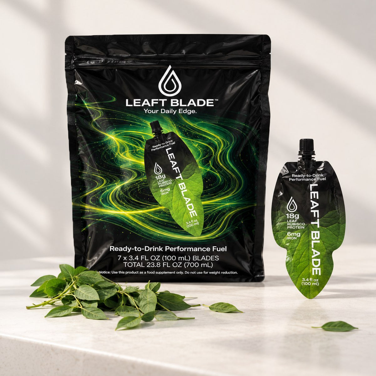 A Leaft Blade 7-pack bag beside a single pouch, with fresh leaves