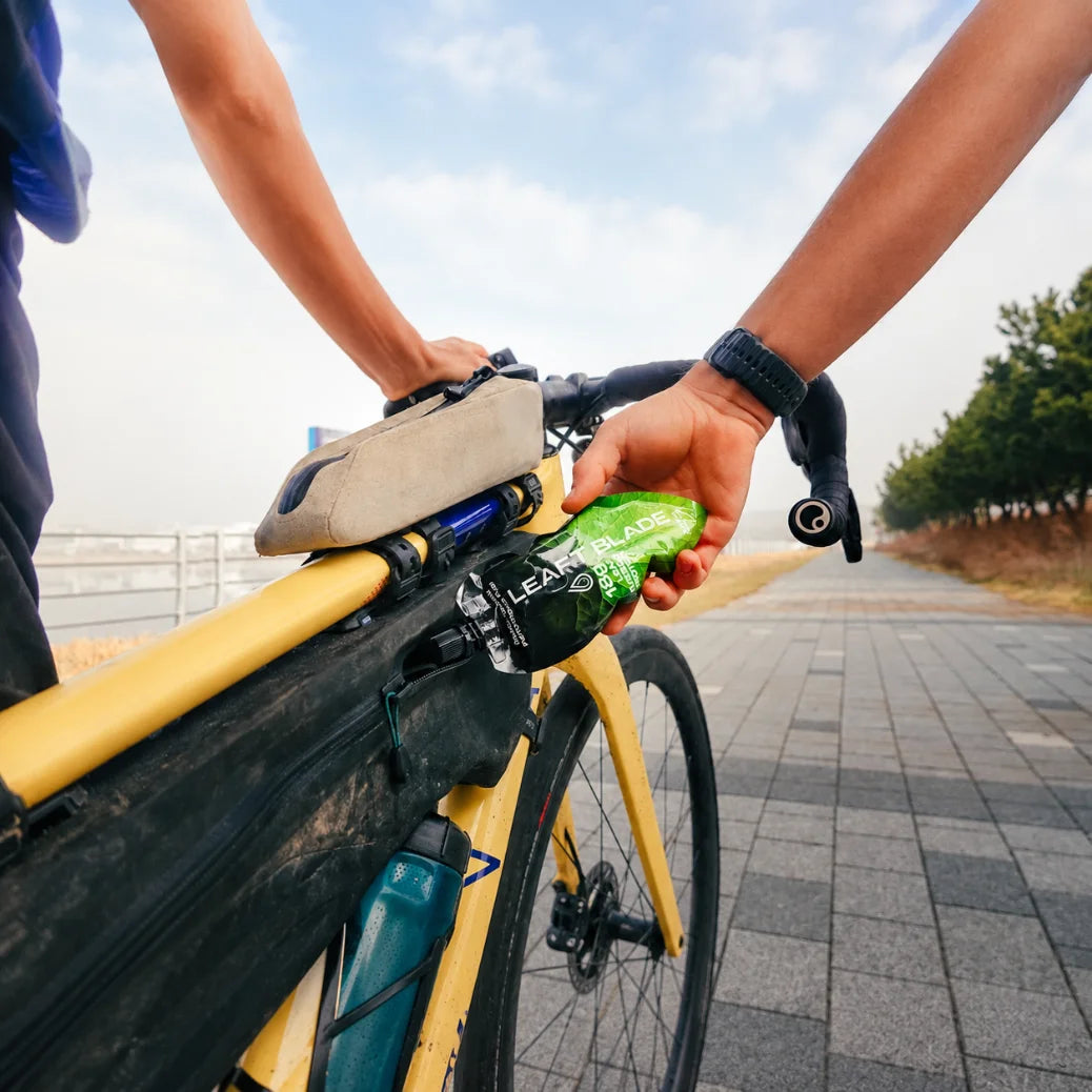 A hand pulling a Blade from a bike frame bag mid-ride